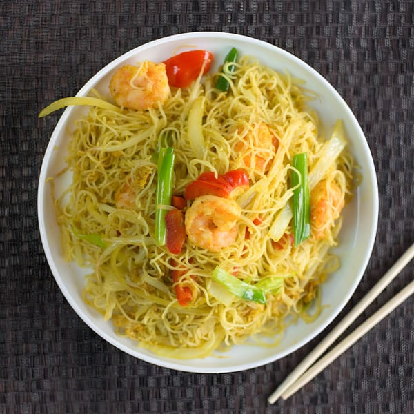 Dragon Dynasty Take Out's Singapore Mei Fun with shrimp, peppers, and scallions, served with chopsticks.
