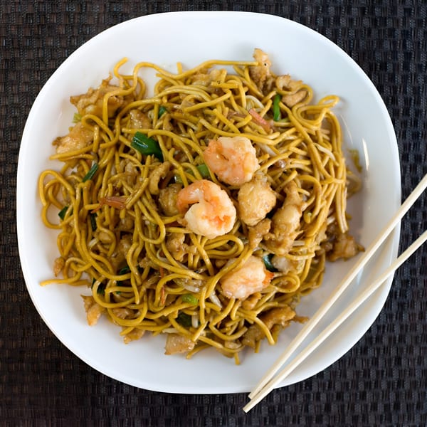 Dragon Dynasty's shrimp and chicken lo mein with vegetables and chopsticks on a dark placemat.